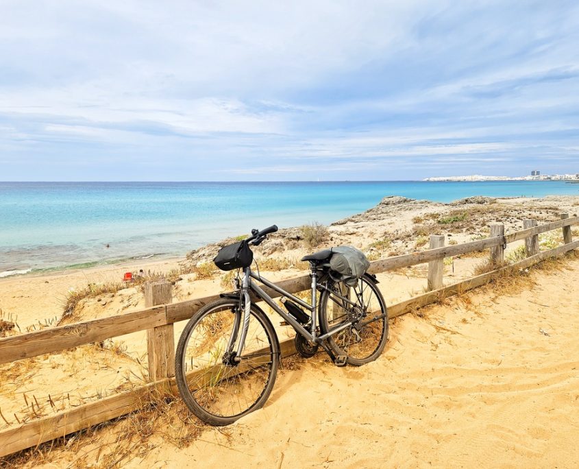 Panoramica della bici con lo sfondo di una spiaggia salentina